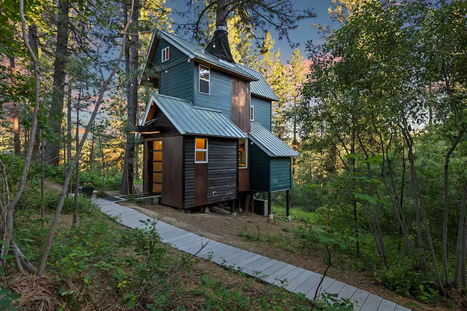 Banks Treehouse exterior at sunset, hand-crafted retreat nestled among Ponderosa pine trees